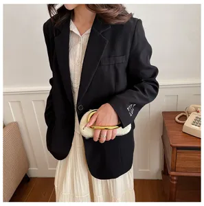 Detail showing the irregular shell-shaped evening clutch bag with a golden handle.