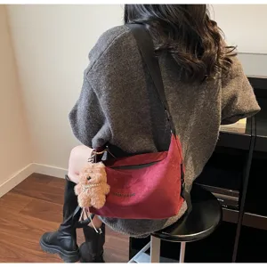 Sac croissant rouge vintage mat avec adorable breloque ours porté par un mannequin