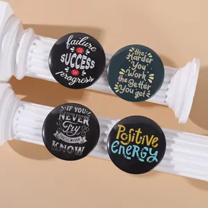 Close-up of four round tinplate badges with inspirational quotes on white pillars.