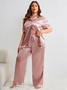 Women's plus size pink satin pajama set with button-up short sleeve top and long pants