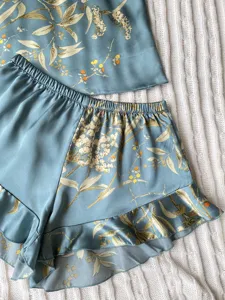 Detailed close-up of floral print blue satin pajama set with ruffle hem shorts