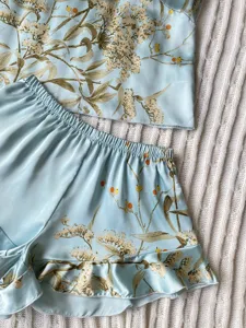Detailed view of the elegant floral print and smooth satin fabric of the pajama set