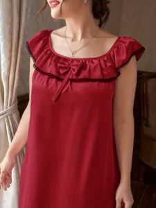 Detailed view of red satin nightgown featuring ruffled neckline and bow accent.