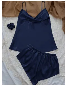 Navy blue silk-like satin pajama set with camisole and shorts on lace background