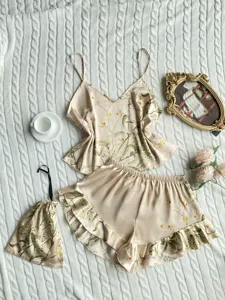Detailed view of champagne floral satin cami and ruffled shorts pajama set with pouch