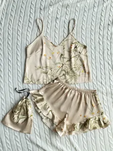 Detailed view of floral satin pajama set with matching drawstring storage bag.