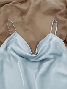 Close-up detail of light blue ice silk pajama top showing soft satin texture and straps