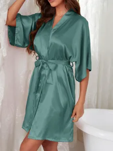 Detail view of a luxury teal satin bathrobe for women in a bathroom setting