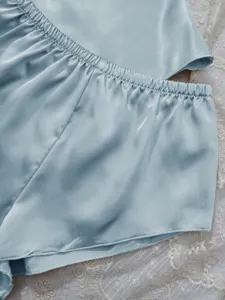 Close-up detail of light blue satin ice silk pajamas showing smooth fabric texture