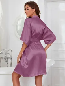 Back view of a mauve satin silk bathrobe with kimono sleeves in a bathroom setting