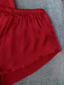 Close-up of vibrant red ice silk pajama shorts showing soft satin fabric texture