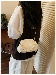 Elegant white floral shell evening bag with pearl handle and chain shown on model