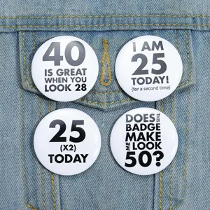 Vue détaillée de quatre badges blancs rigolos pour anniversaire sur une veste en jean.