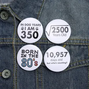 Gros plan de badges en fer-blanc à thème humoristique sur l'âge et les maths