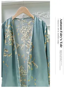 Close-up detail of teal floral print satin robe featuring delicate cherry patterns