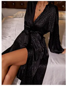 Detail view of a black leopard print silk robe with an elegant tie waist design