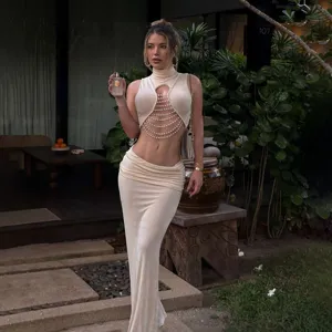 Slim mock neck sleeveless cutout pearl chain crop top paired with low waist maxi skirt.