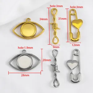 Stainless steel heart safety pin and evil eye charm pendants with specific dimensions.
