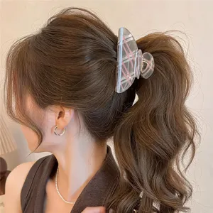 Primer plano detallado de una elegante pinza para el cabello a cuadros transparente.