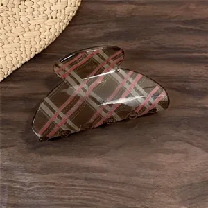 Detalle de pinza para pelo a cuadros clásica, accesorio retro elegante para peinados elegantes.
