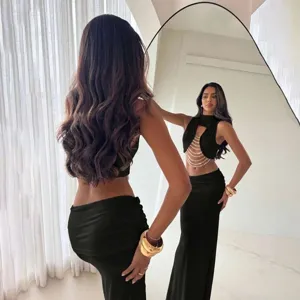 Detailed view of women black halter crop top with pearl chains and elegant low waist maxi skirt.