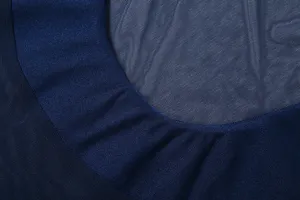 Primo piano dei dettagli del tessuto in rete blu scuro e del colletto dell'abito sexy aderente.