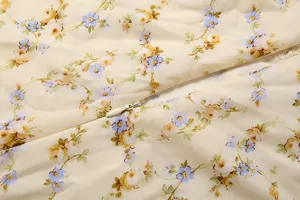 Close-up detail of floral print fabric and hidden zipper on light yellow dress material.
