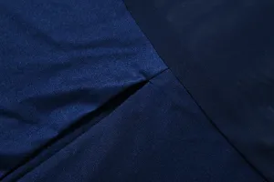 Dettaglio del tessuto dell'abito blu scuro, che evidenzia mesh e cuciture lisce.