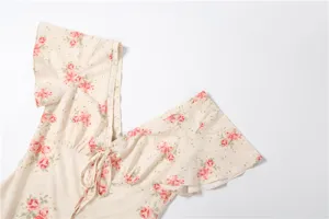 Floral print V-neck dress detail view showing short flutter sleeves and cute front tie bow.