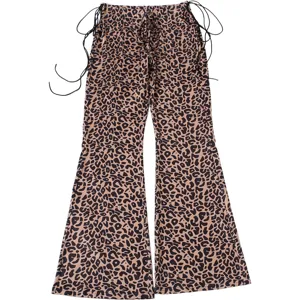 Close-up detail of trendy leopard print low-waist flare pants with side drawstring ties.