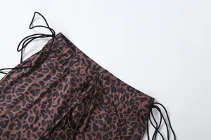 Detail view of women low waist leopard print trousers with black side drawstrings.