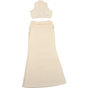 Detail shot of the beige sleeveless crop top and long skirt set, showing soft fabric texture.