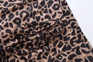 Leopard print pants fabric detail showcasing trendy slim micro-flared style with drawstring accent.