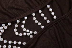 Exquisite women's slim knit apparel detail featuring elegant pearl chain cutout design.
