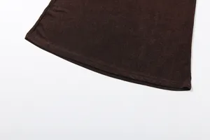 Detailed close-up shot of dark brown apparel hem showcasing fine fabric texture.
