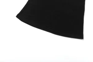 Black clothing hem detail, premium fabric texture, minimalist white background showcase.