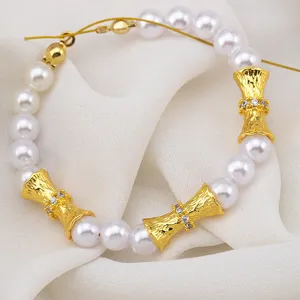 Elegant gold-plated ribbed spacer beads with crystals on a pearl strand for DIY jewelry.