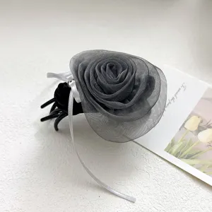 Gros plan d'une élégante pince à cheveux rose en tulle gris avec ruban et perle