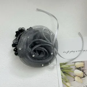 Détail d'un élastique à cheveux élégant en tulle gris en forme de rose avec perles