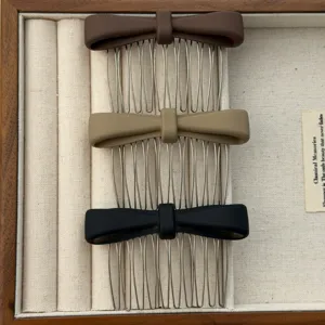 Detail shot of three elegant matte bow hair combs in brown, khaki, and black colors