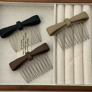 Detail view of minimalist matte bow hair combs in black, brown, and khaki tones.