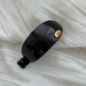 Eleganter glänzender schwarzer ovaler Bananen-Haarclip mit goldenem Handmade-Label