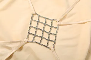 Close-up detail of women's rhinestone lattice strap dress featuring sparkling crystal mesh accent.