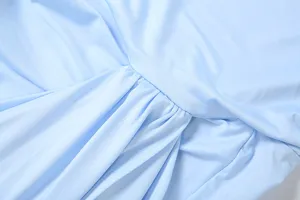 Hellblauer Kleidungsstoff Detail, feine Falten und saubere Nähte Nahaufnahme Ansicht.