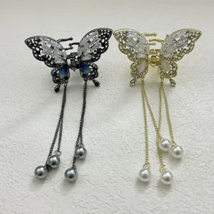Detailed view of elegant butterfly hair claw clips with long tassels and pearls