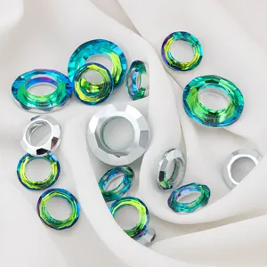 Faceted colorful glass angel ring beads for DIY jewelry making on soft white fabric.