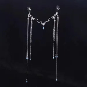 Close-up detail of bridal forehead hair chain with silver filigree and blue water drop crystals