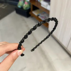 Close-up of wavy black crystal headband showing delicate faceted bead details