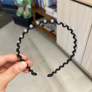 Close-up of a black wavy headband decorated with sparkling crystal beads