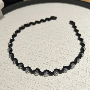 Macro view of black wavy headband with clear crystal bead embellishments